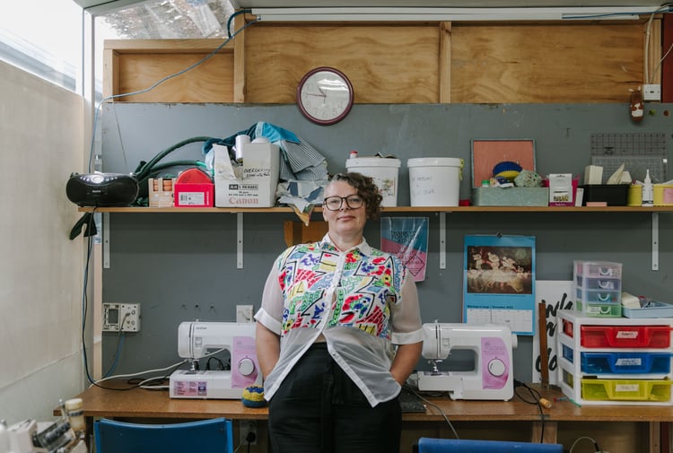 Samantha Fay looking to camera inside her studio.