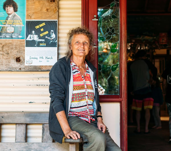 A woman sitting down looking at camera.