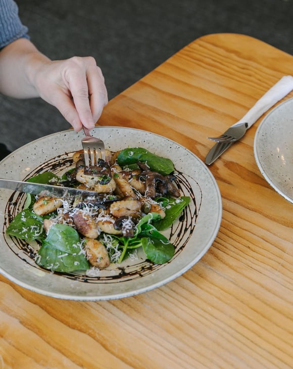 A woman about to eat a meal at a table inside Moutere Inn in  the Tasman District.