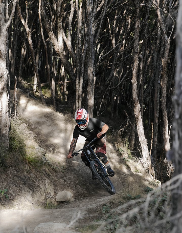 Man riding downhill through forest at Middle Hill MTB.