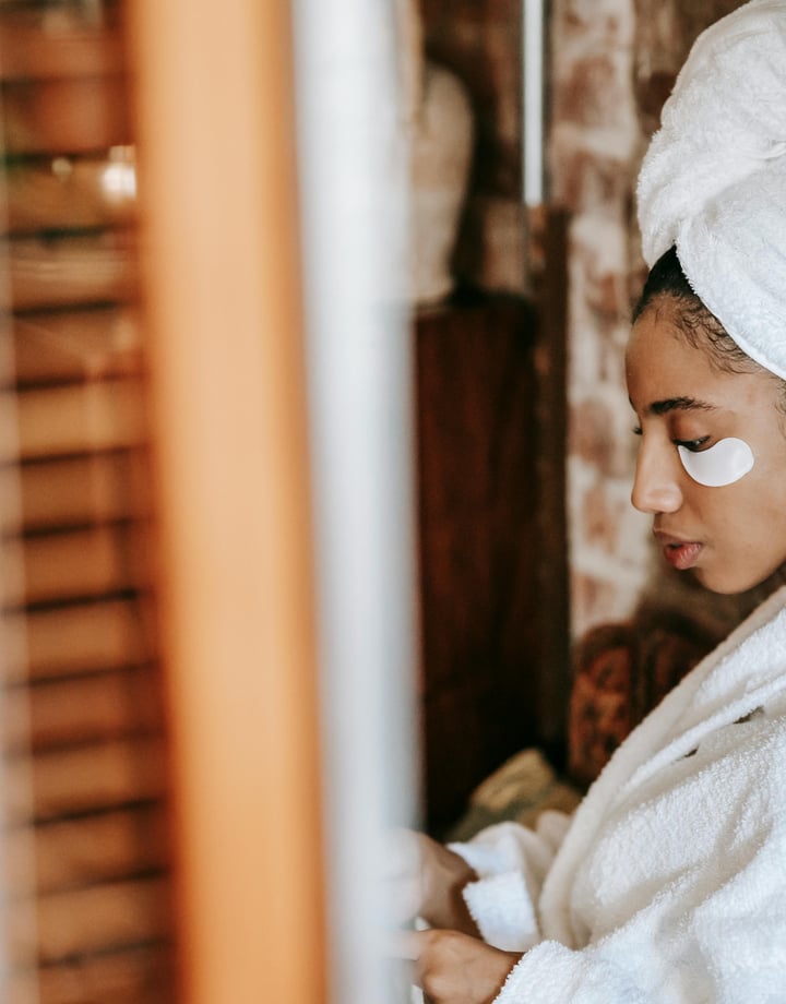 Women in spa with under-eye skincare patches wearing a dressing gown and towel wrapped around head