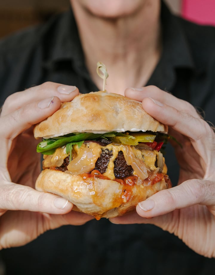 Close up of hands holding a vegan burger.