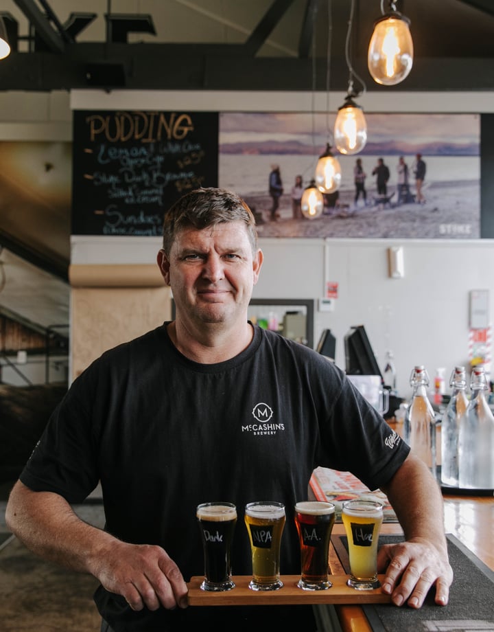 Man holding beer flight from McCashin's.