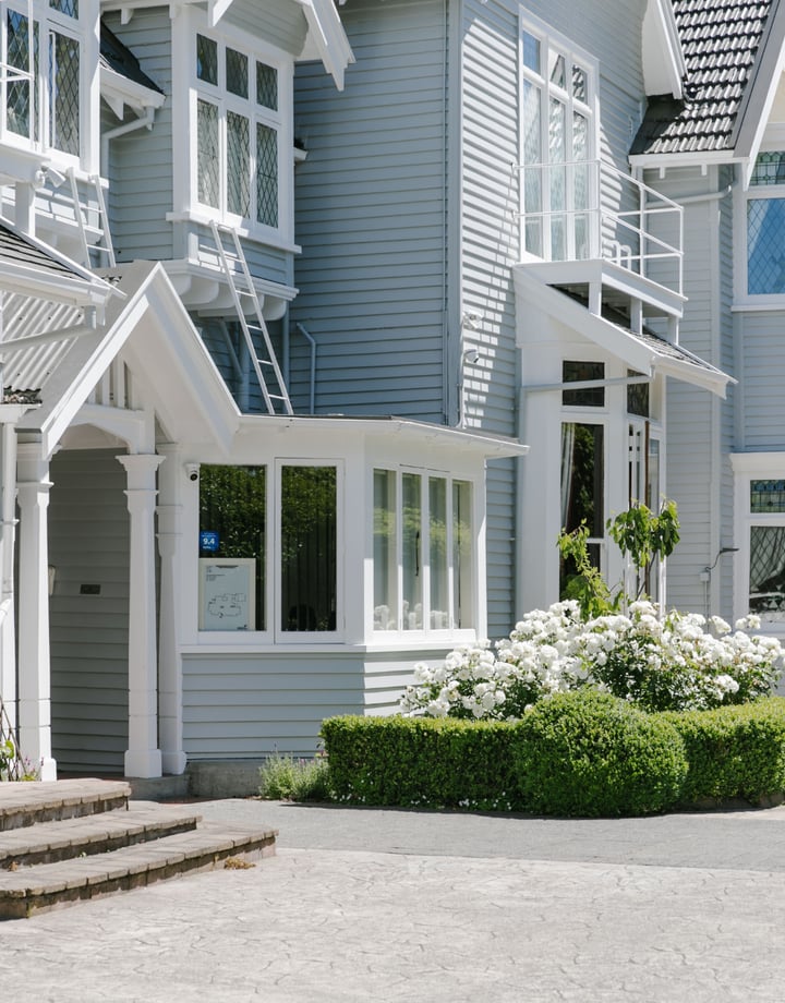 The exterior of Christchurch accommodation with roses and hedged in front.