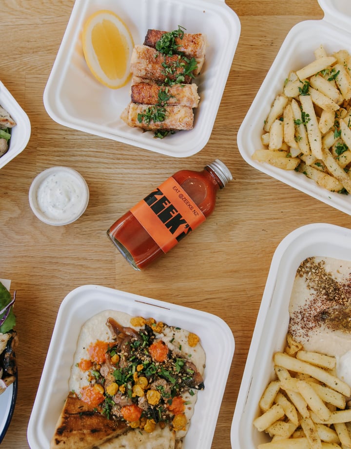 A flatlay of salads and hot chips on a table at Zeek's.