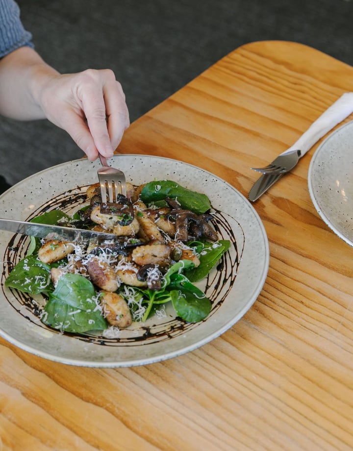 A woman about to eat a meal at a table inside Moutere Inn in  the Tasman District.