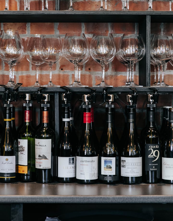 Bottles of red wine lined up in a row on a table.