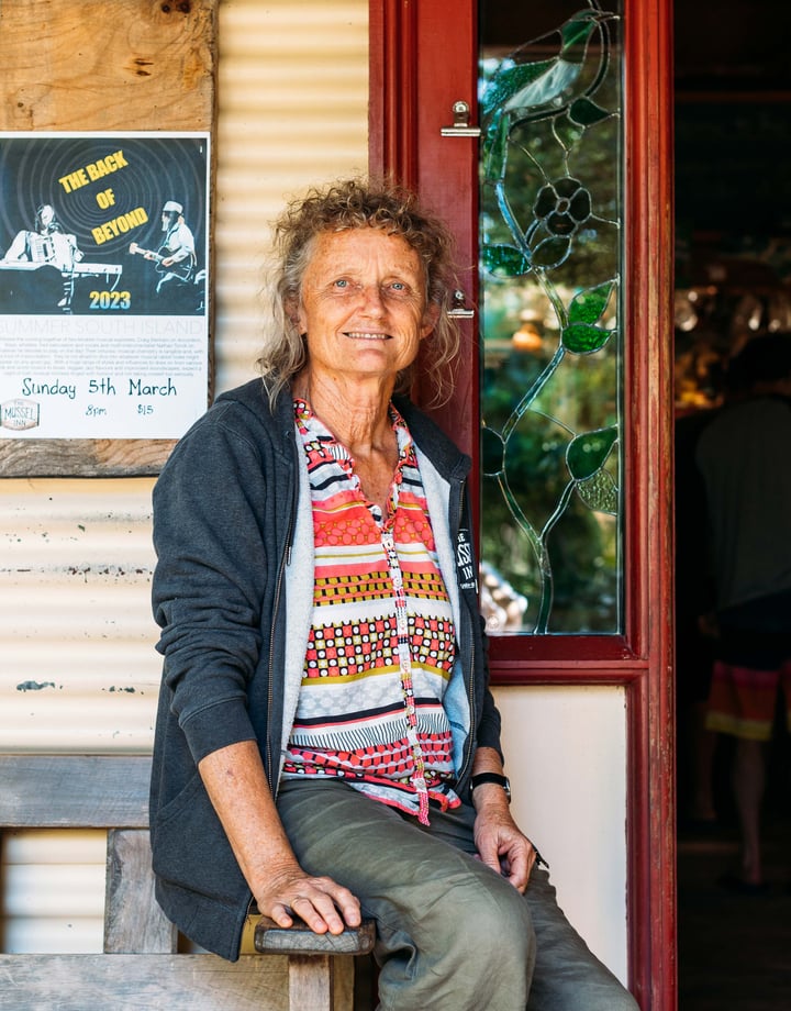 A woman sitting down looking at camera.