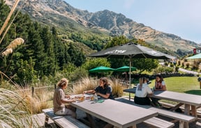 People dining outside in Queenstown on a sunny day.