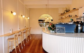 A high leaner with chairs runs the length of wall opposite the counter at Comes & Goes café in Petone.