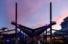 The V-shaped roof structure of Eat Streat against a pink and blue dusky sky.