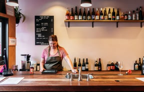 A staff member working behind the counter at House Wine bar New Plymouth.