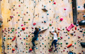 Close up of two girls climbing on the bouldering wall.
