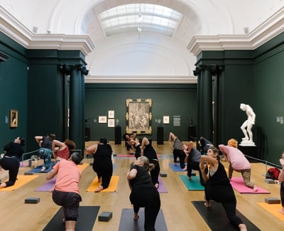 People doing a yoga class inside Auckland Art Gallery exhibition room