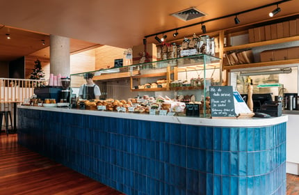 Bakery interior with royal blue tiles and a cabinet filled with delicious baked goods