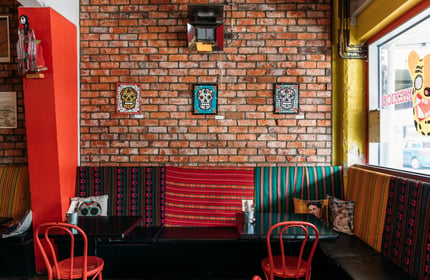 Interior of Mexican restaurant with exposed brick walls, Mexican skull mosaics and Day of the Dead decor