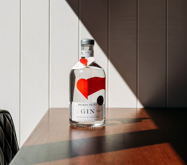 A bottle of gin sitting on a table in the sunshine.