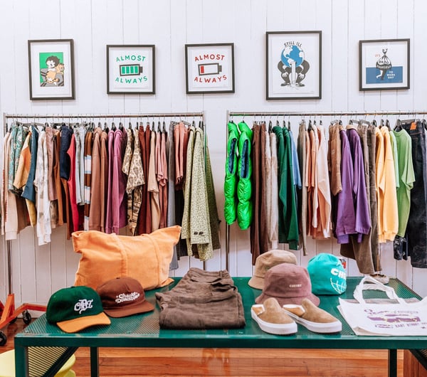 Interior image of Checks clothing store with a table of hates and shoes.