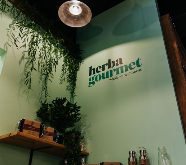 A painted Herba Gourmet sign on the interior wall.