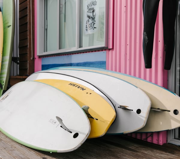 Stack of surfboards leaning against a wall at Kaikōura Surf Company.