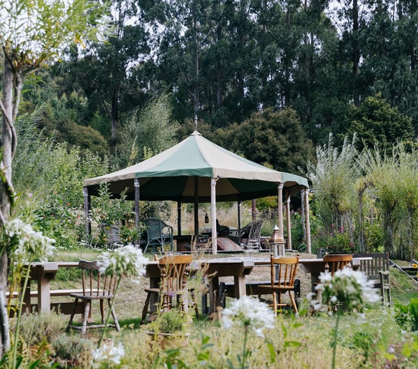A yurt surrounded by tables and chairs at Okuti Garden in Little River.