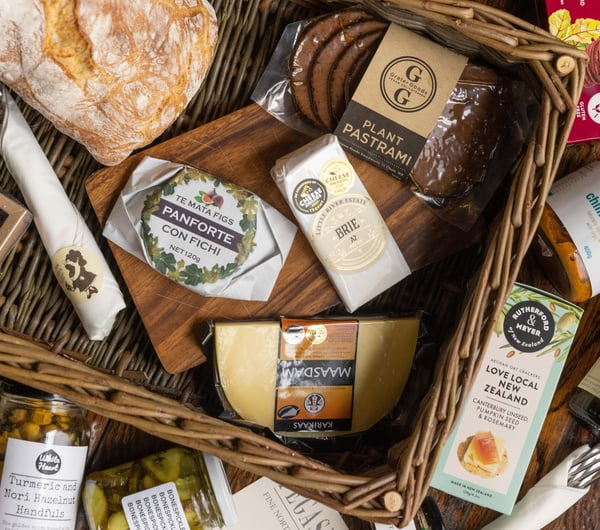 A flatlay of cheese and spreads in a basket.