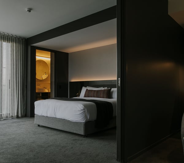 A dark grey and white bedroom inside The Mayfair Christchurch.