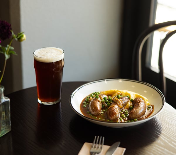 A beer and bangers and mash on a table at Victoria Free House Christchurch.