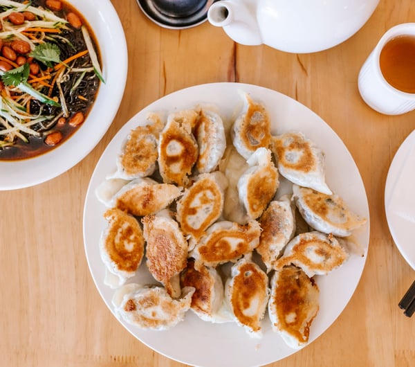 A flatlay of a plate of dumplings on a table.