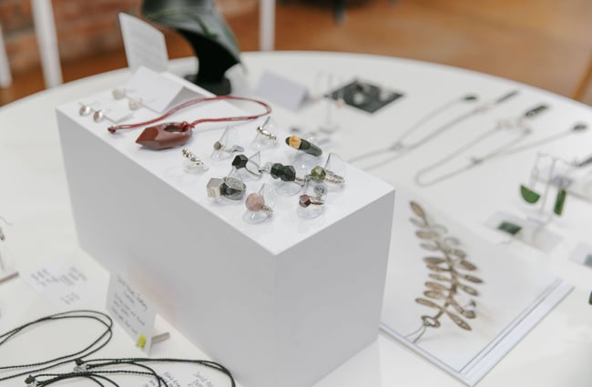 Rings and necklaces on display on a white table at 77 Art + Living in Fairlie.