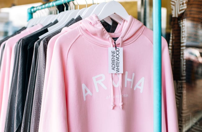 Close up of a pink hoodie hanging on a rack.