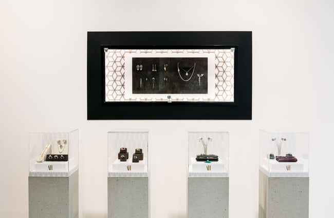 A close up of jewellery displayed on concrete plinths.