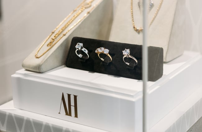 A close up of three diamond rings on display in a glass cabinet.