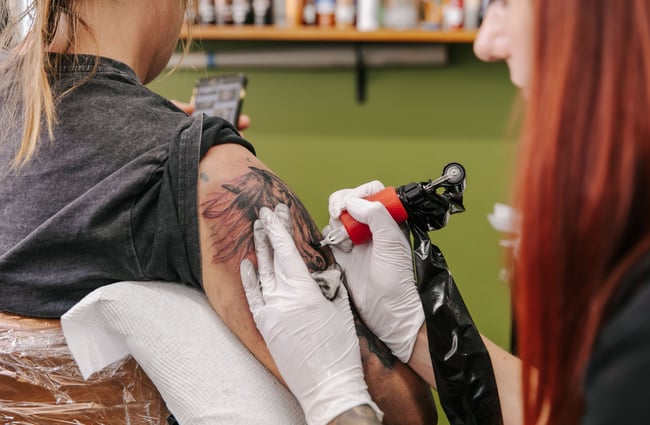 Close up of woman getting a tattoo on her arm.