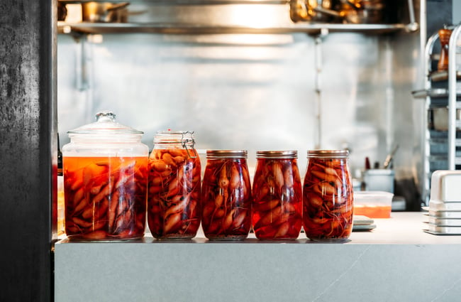 A close up of stewed fruit in jars lined up in a row.