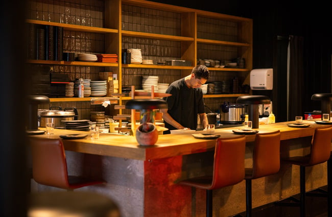 A male staff member working at a counter inside Azabu restaurant.