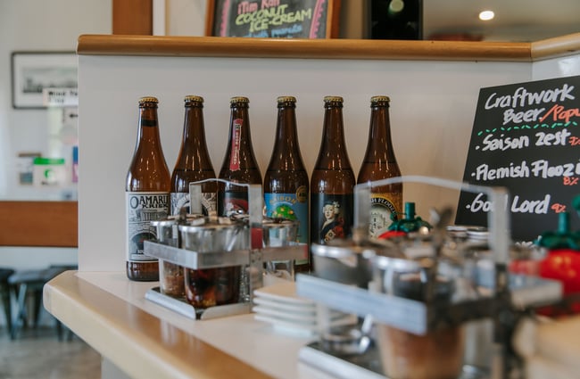 A close up of bottles of beer on the front counter.