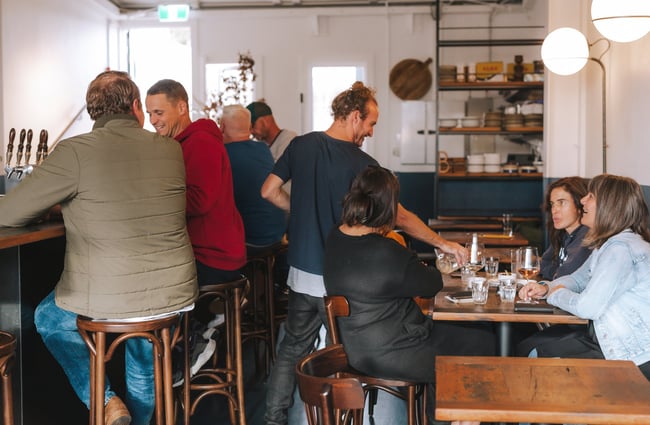 A table of customers being served by a man at Bar Martin, Auckland.
