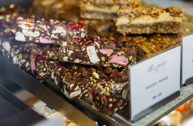 A close up of rocky road behind a glass counter.