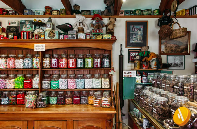Lollies full of jars on display on wooden cabinetry.