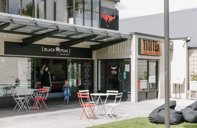 The exterior of Black Peak Gelato with tables and chairs and beanbags for customers.