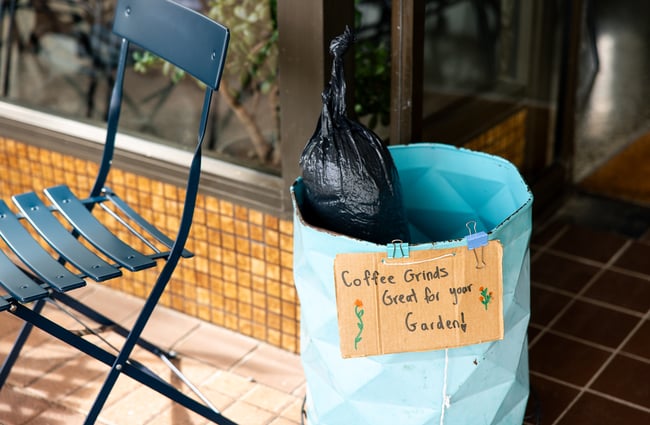 A close up of a bag of used coffee outside a cafe.