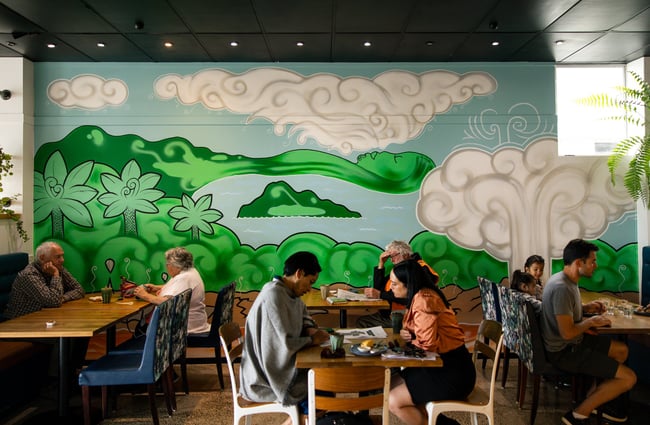 A large green and blue mural on a cafe wall.