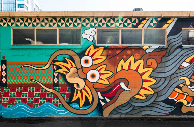 A colourful painted mural of a orange and yellow dragon.