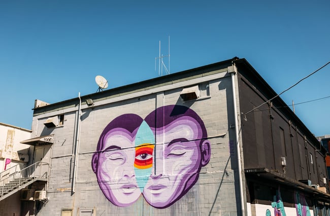 A colourful painted mural of a man's face with third eye.