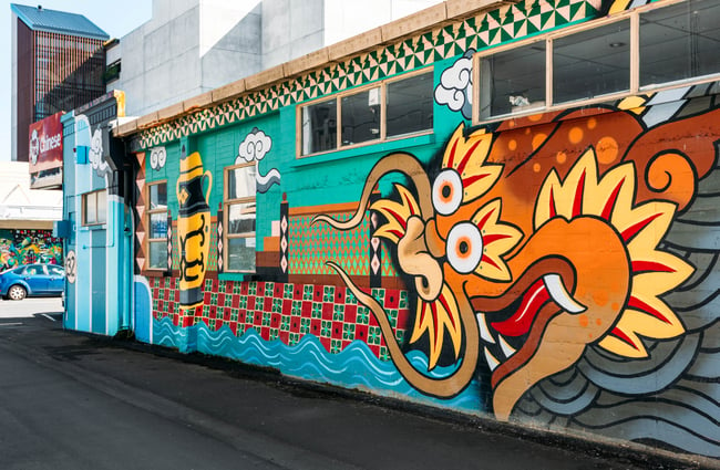 A colourful painted mural of an orange and yellow dragon.
