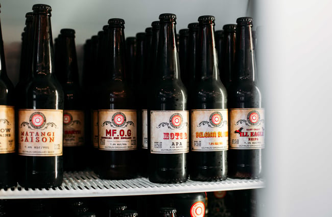Bottled beer stocked in rows inside a fridge.
