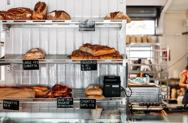 Bread on display on shelves inside a cafe.