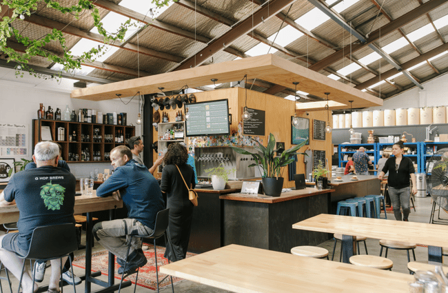 The interior of the Brew Academy in Christchurch with wooden tables scattered through the room.