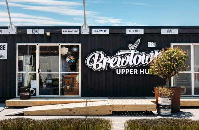 A large white sign a container that says 'Brewtown'.